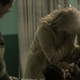 A judgmental nurse looks on as Offred comforts her daughter.